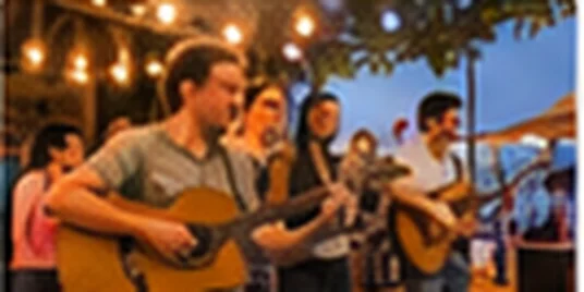 Músicos tocando violão em apresentação cultural em Adamantina